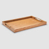 Wooden tray with brass handles on a light gray background